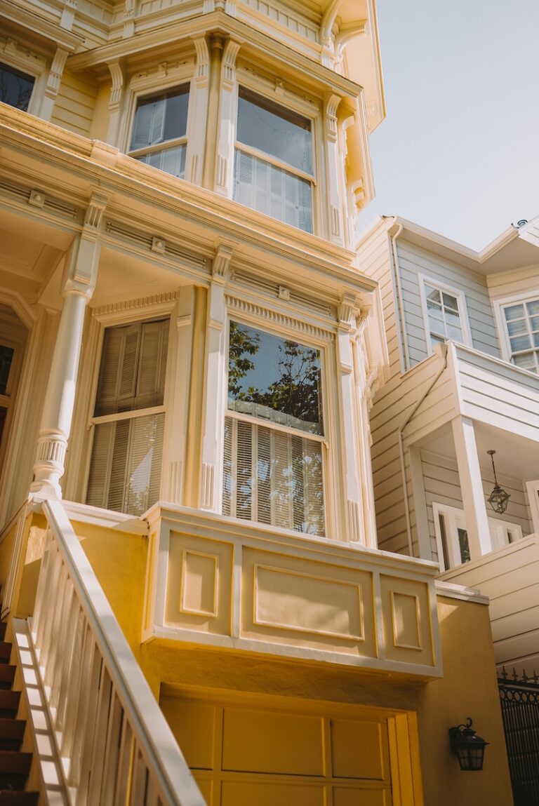 a yellow house with a white staircase leading up to it